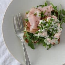 An open ham sandwich on a plate with a fork