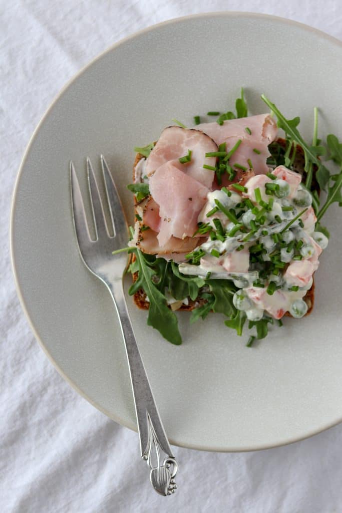 An open ham sandwich on a plate with a fork