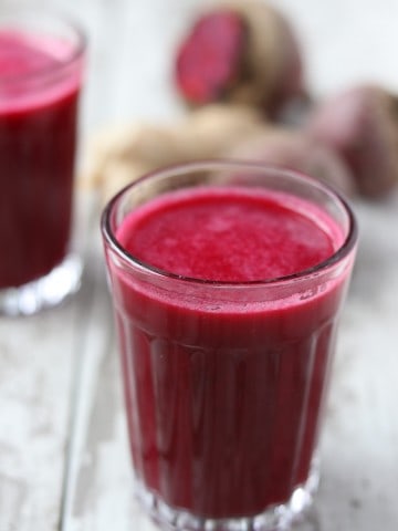 A close up of a glass of beet apple ginger smoothie