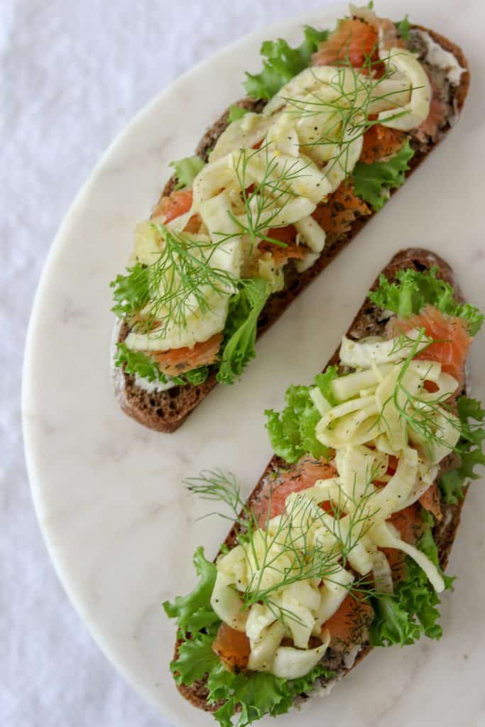 An open sandwich with smoked salmon and fennel on a plate