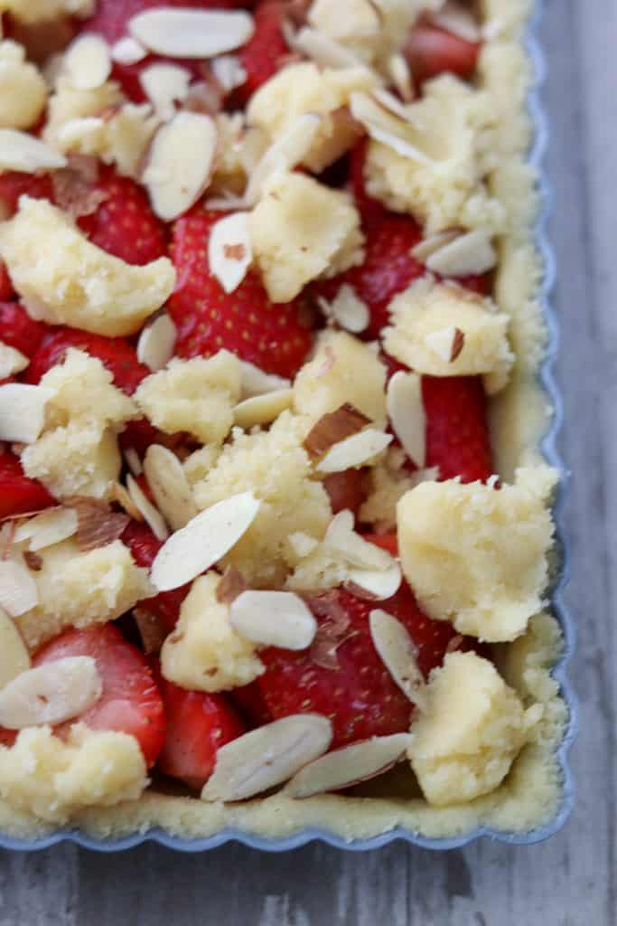 A close up of an unbaked strawberry almond tart