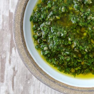 A close up of a bowl of fresh herb sauce