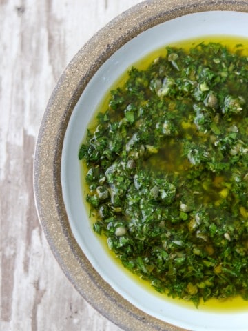 A close up of a bowl of fresh herb sauce