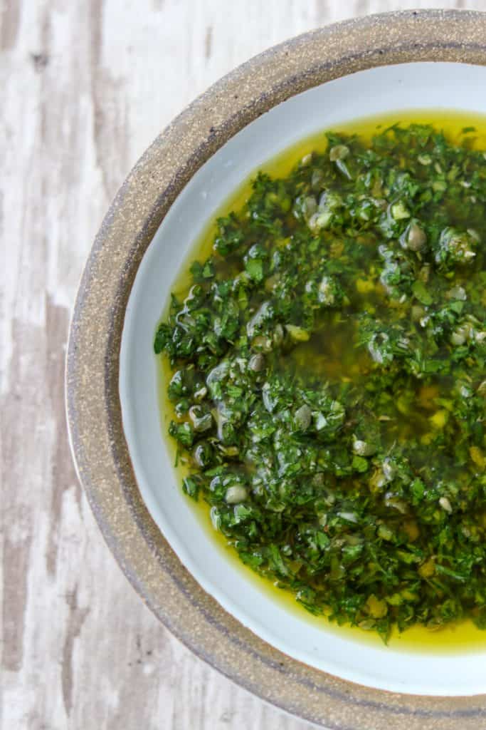 A close up of a bowl of fresh herb sauce 