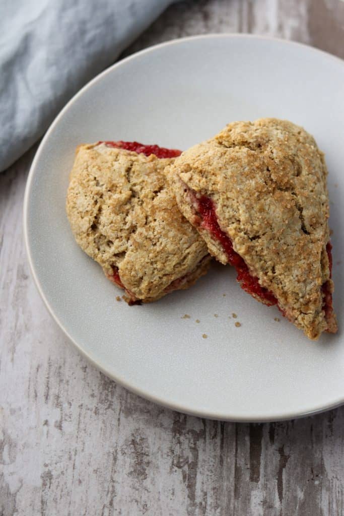 Two strawberry rhubarb scones stacked on a plate