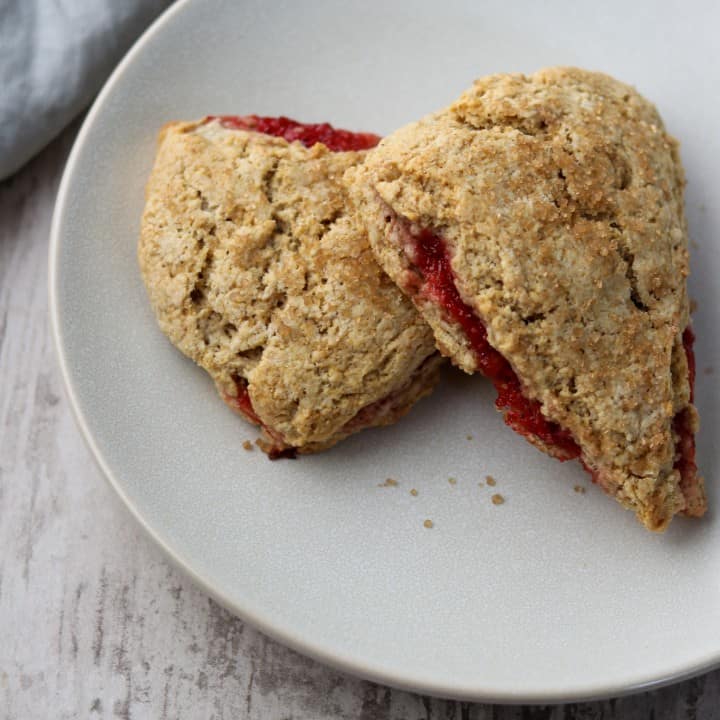 Two strawberry rhubarb scones stacked on a plate