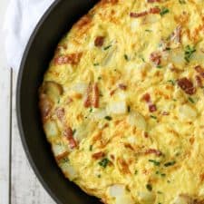 Danish egg cake in a pan sitting on a kitchen towel