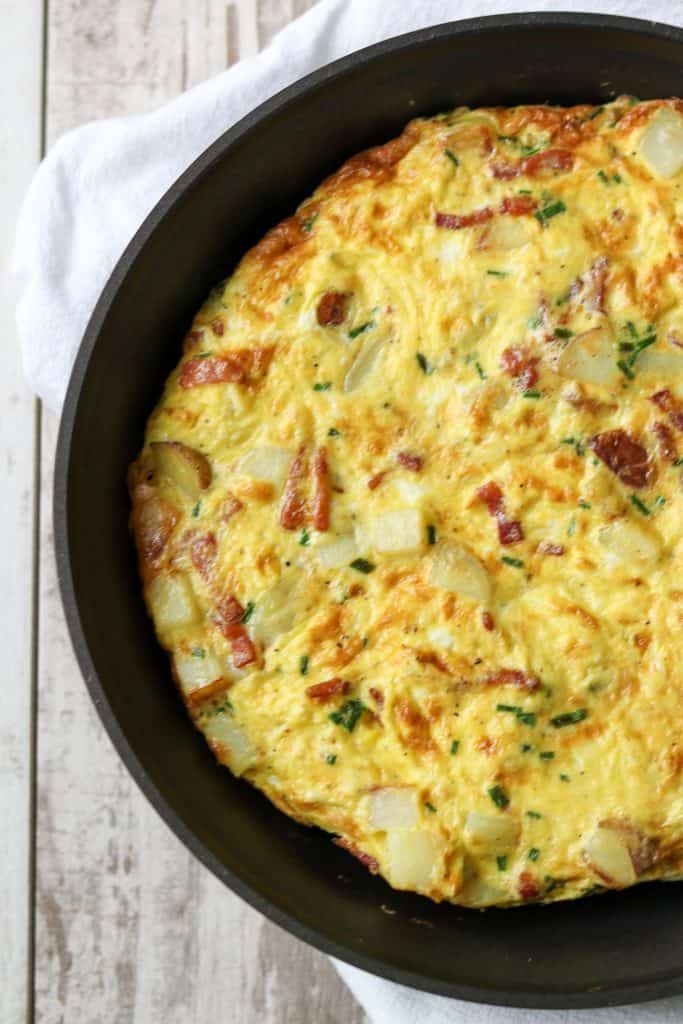 Danish egg cake in a pan sitting on a kitchen towel