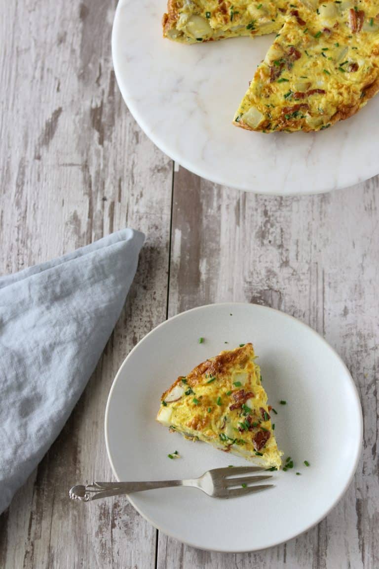 A slice of Danish egg cake on a plate next to a blue napkin