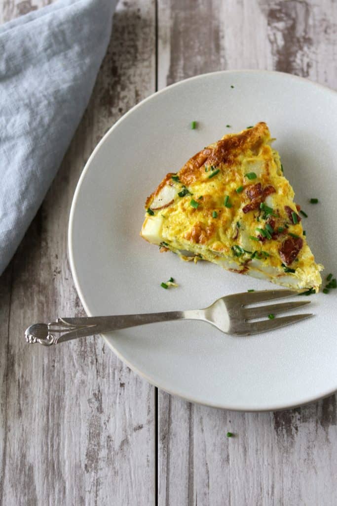 A slice of Danish egg cake on a plate with a fork and napkin