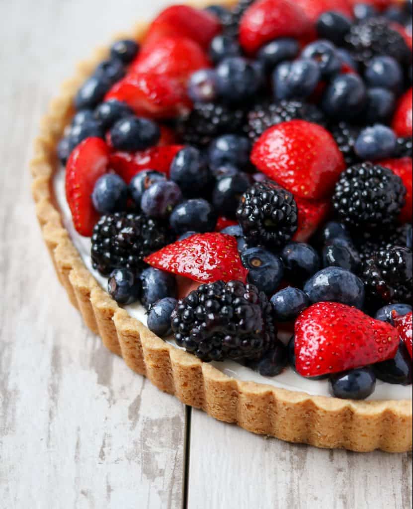 A close up of a skyr tart with fresh berries on a wooden surface