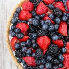 A skyr tart with fresh berries on a wooden surface