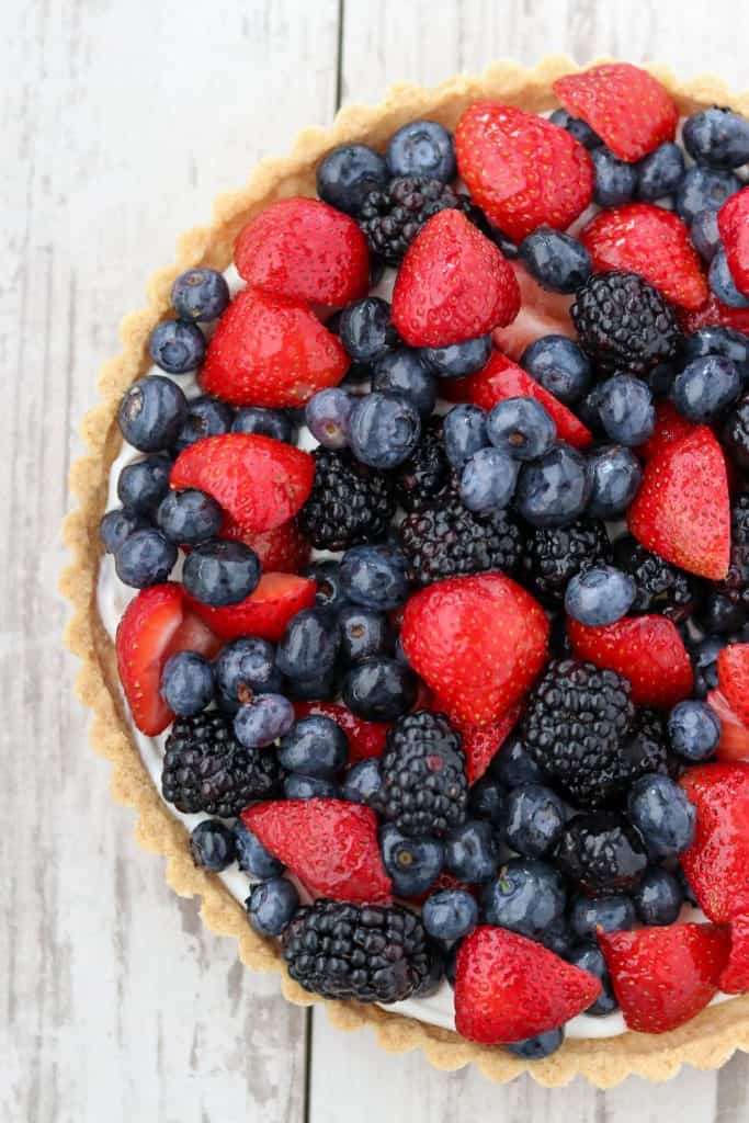 A skyr tart with fresh berries on a wooden surface