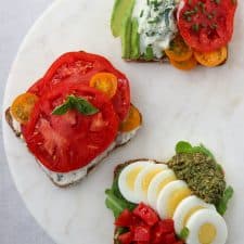 Open sandwiches with tomatoes and egg on a marble plate