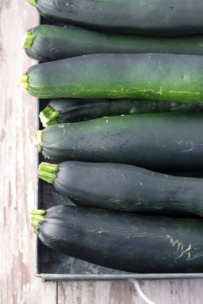 A pile of zucchini on a wooden surface