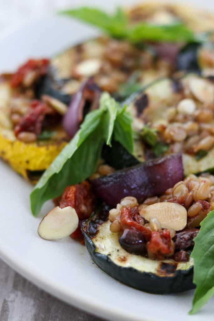 A close up of grilled summer squash salad with basil leaves