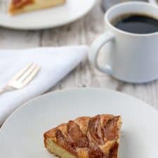 A slice of Swedish apple cake with a fork, napkin and a cup of coffee