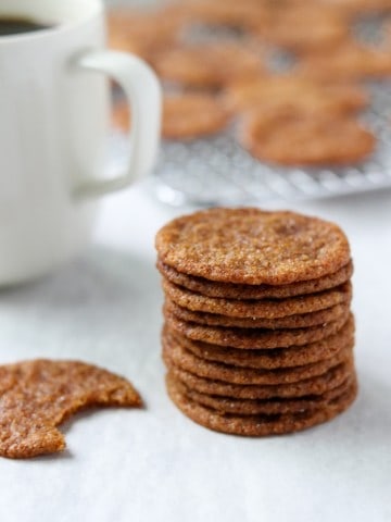 A close up of a stack of Swedish ginger snaps and a cup of coffee