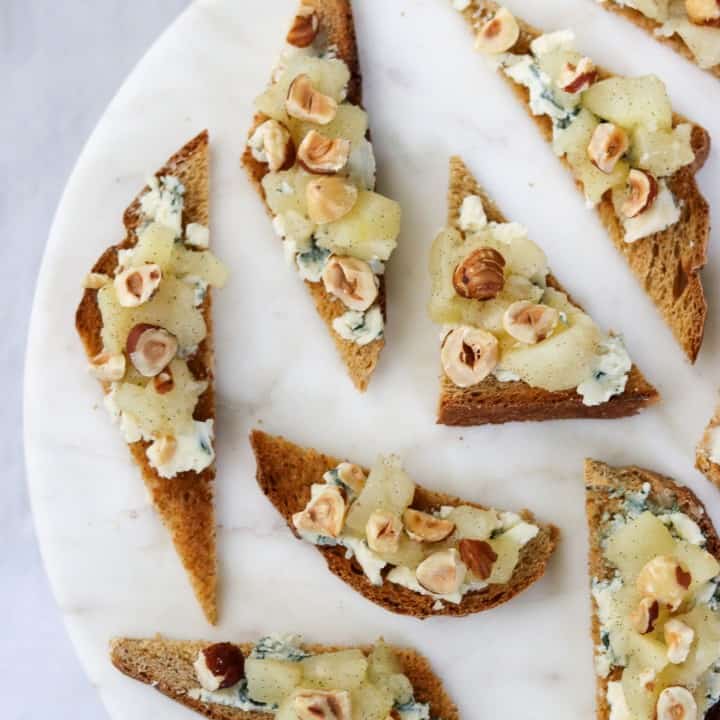 Open sandwiches with blue cheese, pears and hazelnuts on a plate