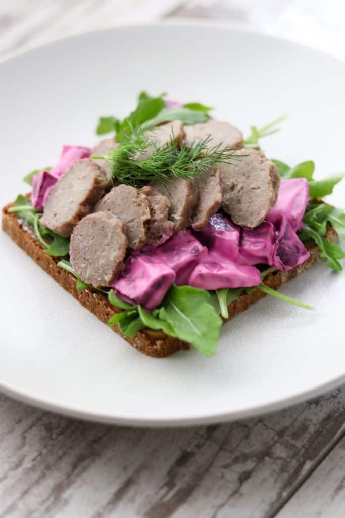 An open sandwich with meatballs and beet salad on a plate