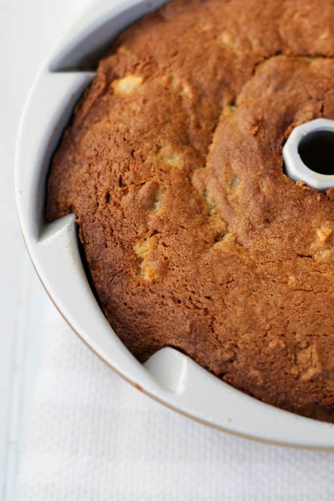 A close up of a baked pear cardamom bundt cake in a cake pan 