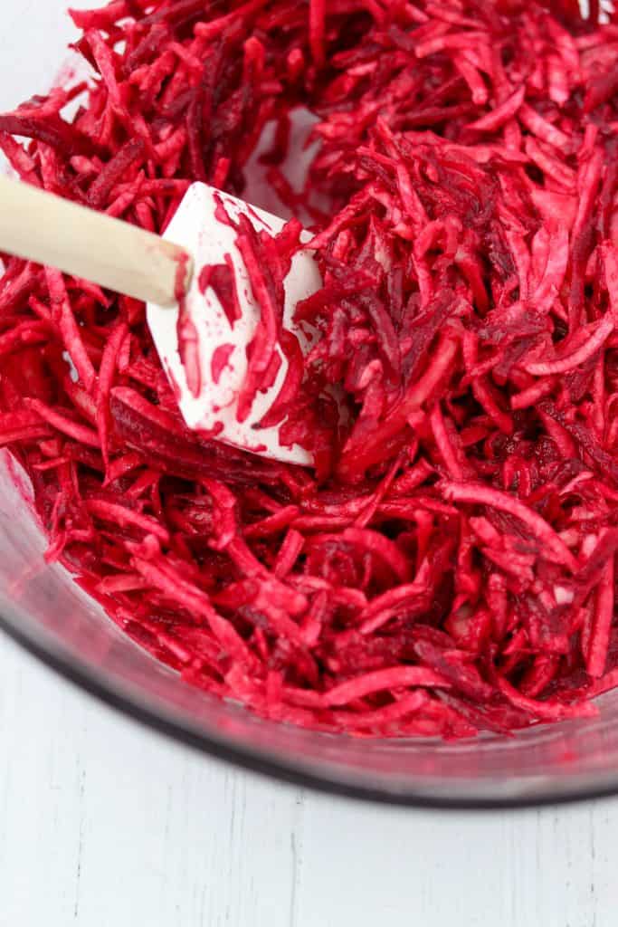 A close up of shredded beets and a spatula