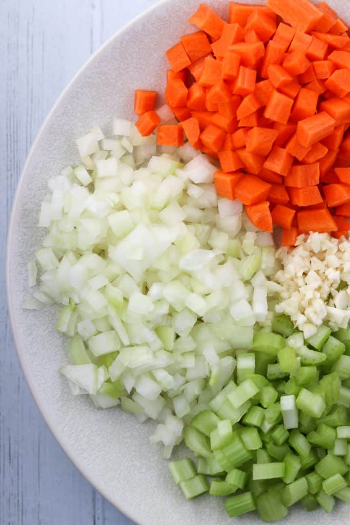 Chopped onion, carrot, celery and garlic on a plate