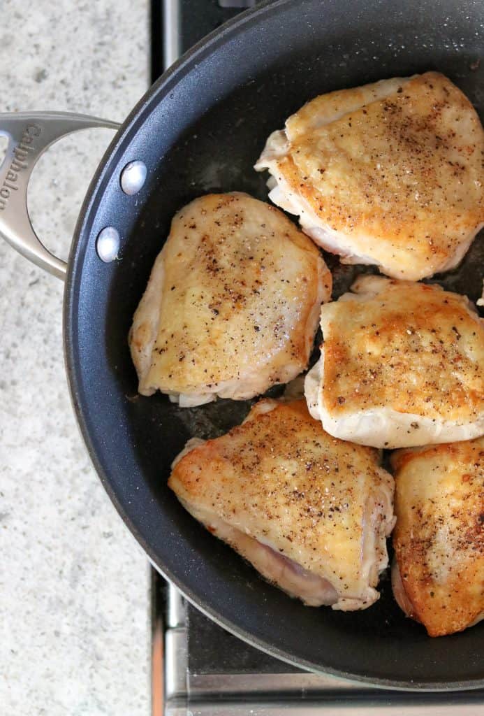Seared chicken thighs in a pan