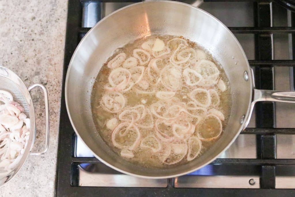 Crispy shallots frying in oil in a pan