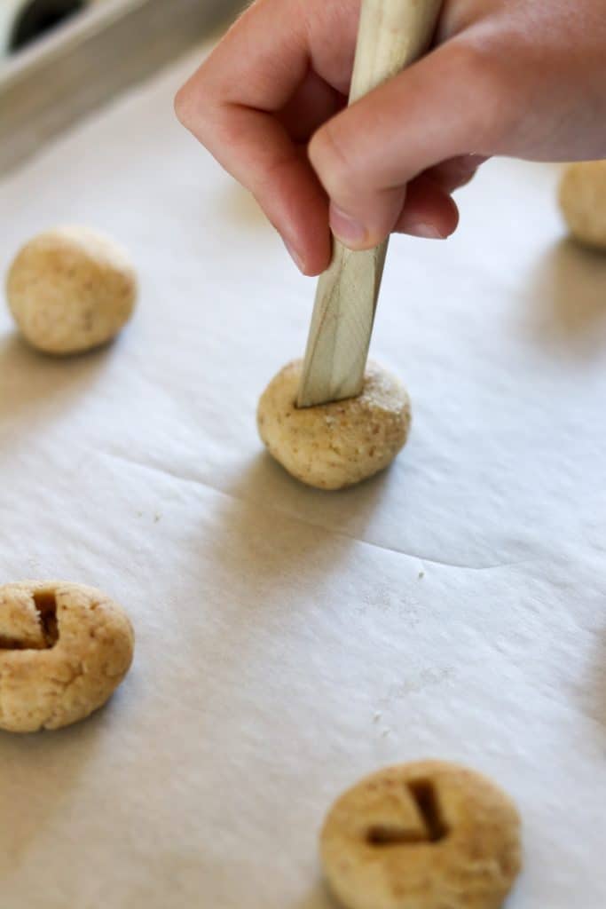 A person making a v shape in a round of cookie dough