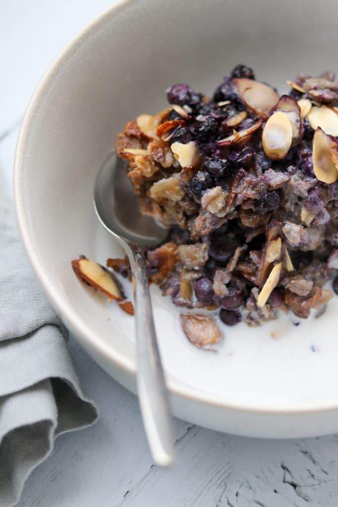 Oat and rye porridge in a bowl with a spoon next to a napkin