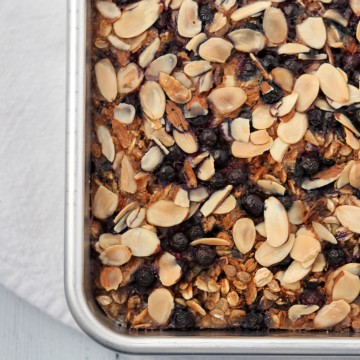 Baked oat and rye porridge with blueberries and almonds in a pan