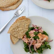 Salmon salad on a plate with crispbread next to a fork