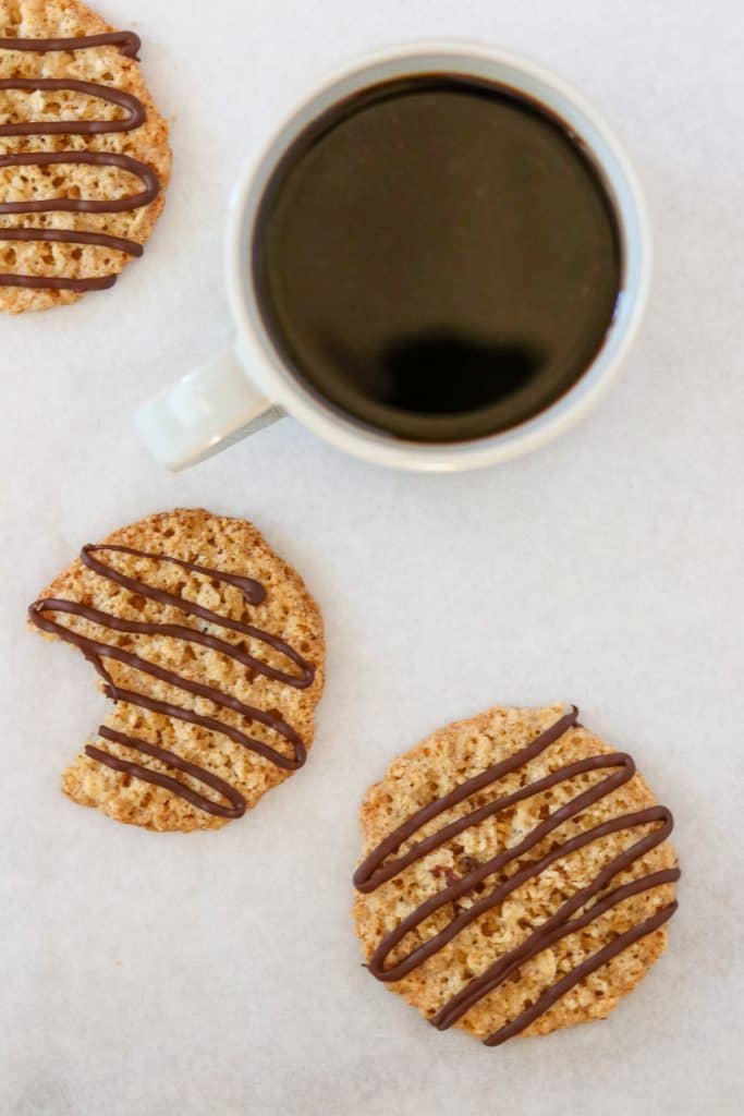 Oat cookies drizzled with chocolate and a cup of coffee