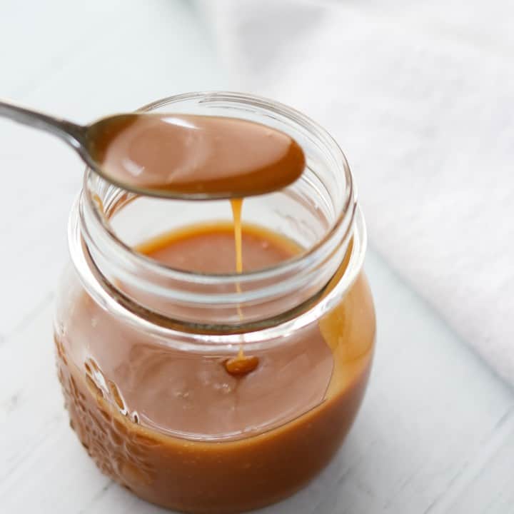 A jar of caramel sauce with a spoon