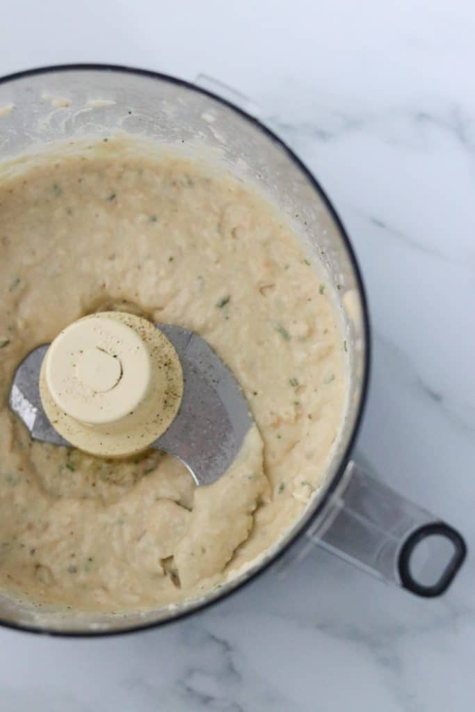 White bean puree in the work bowl of a food processor