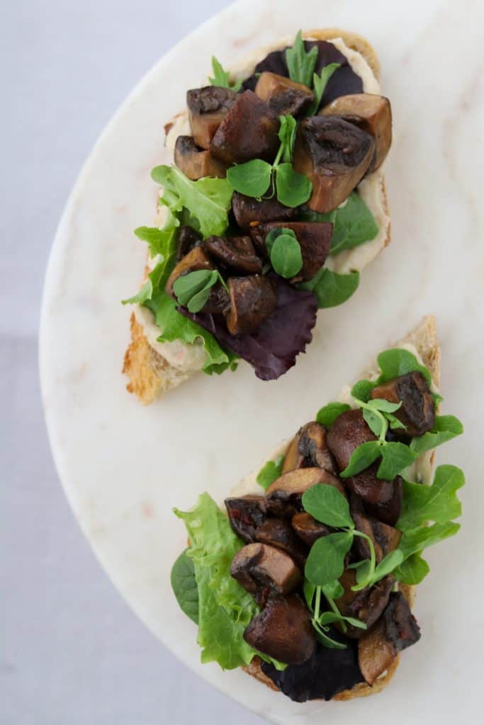 Open sandwiches on a plate with lettuce and mushrooms