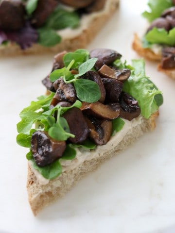 A close up of an open sandwich with mushrooms and lettuce