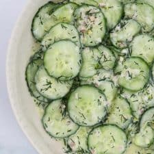 A bowl of sliced cucumber salad with fresh dill