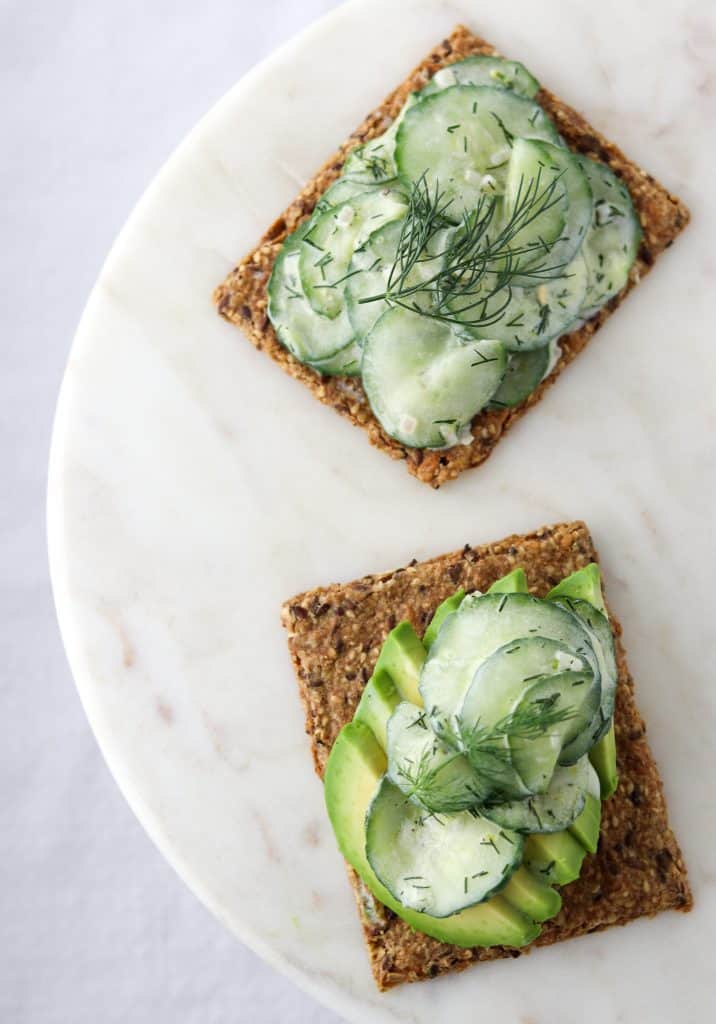 Slices of toast topped with cucumber salad and dill