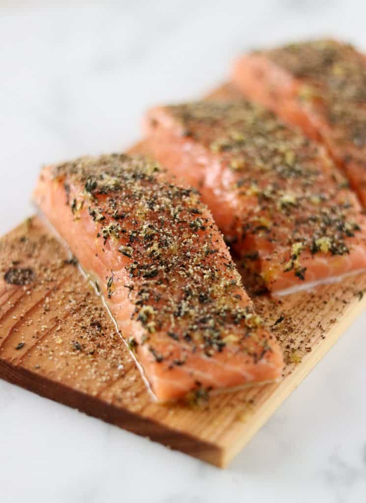 A close up of salmon filets on a cedar plank