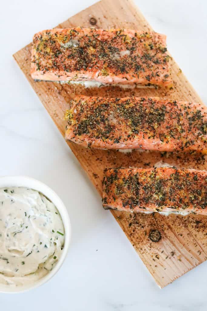 Grilled salmon filets on a cedar plank with a creamy sauce