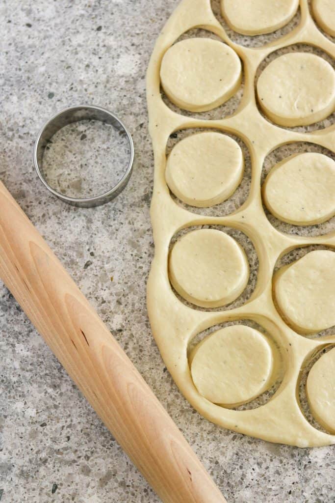 Bun dough cut into circles with a biscuit cutter and rolling pin