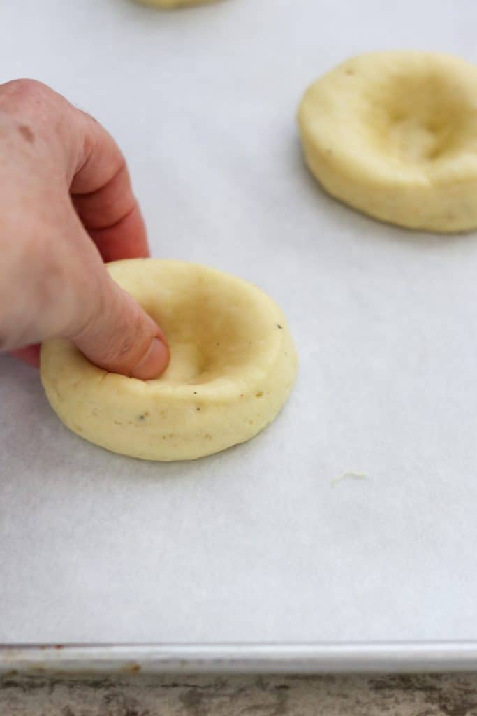 A person shaping dough into a bun