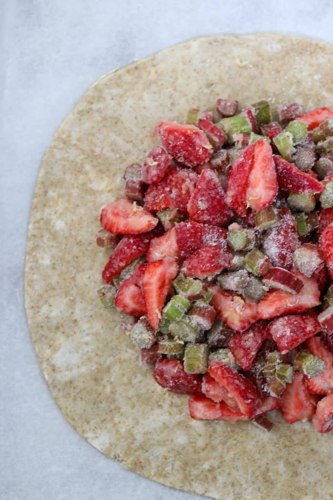 Galette dough topped with strawberries, rhubarb and sugar