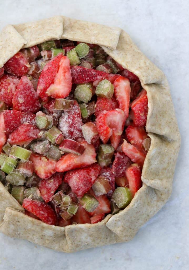 Unbaked galette filled with strawberries and rhubarb
