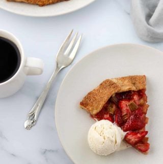 Slice Rustic Strawberry Rhubarb Rye Galette on a plate with ice cream
