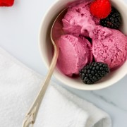 Frozen berry skyr yogurt in a bowl with fresh berries and a spoon