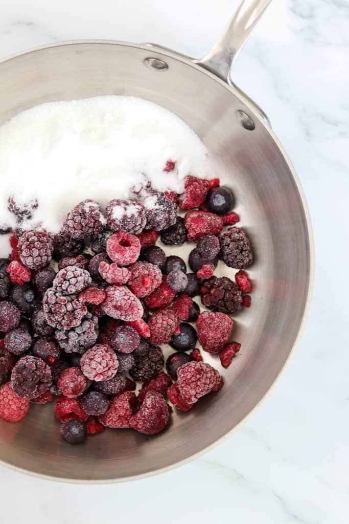 Frozen berries and sugar in a pan