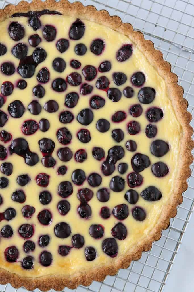 A close up of a blueberry tart on a cooling rack